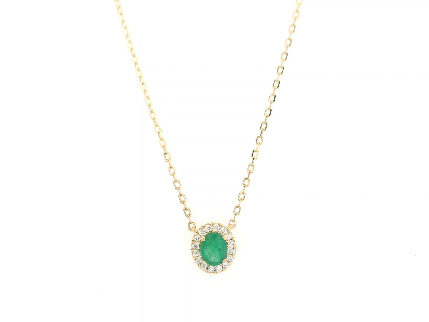 Emerald and diamond halo necklace in 18K yellow gold featuring 0.51 carat emerald and 0.10 carat diamonds by Emirates Diamonds.