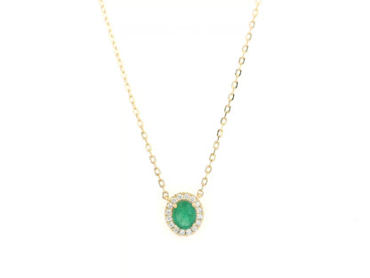 Emerald and diamond halo necklace in 18K yellow gold featuring 0.51 carat emerald and 0.10 carat diamonds by Emirates Diamonds.
