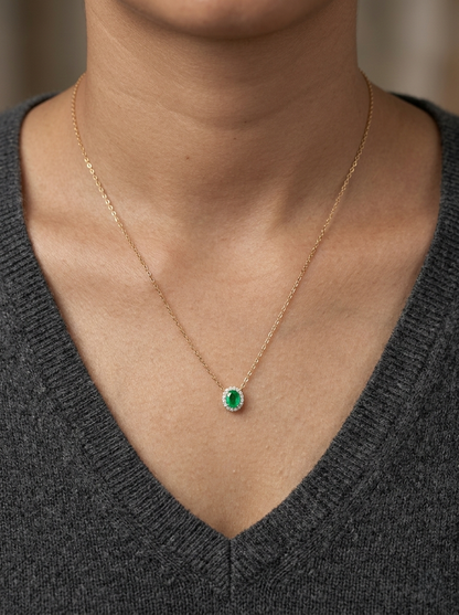 Emerald and diamond halo necklace in 18K yellow gold featuring 0.51 carat emerald and 0.10 carat diamonds by Emirates Diamonds.