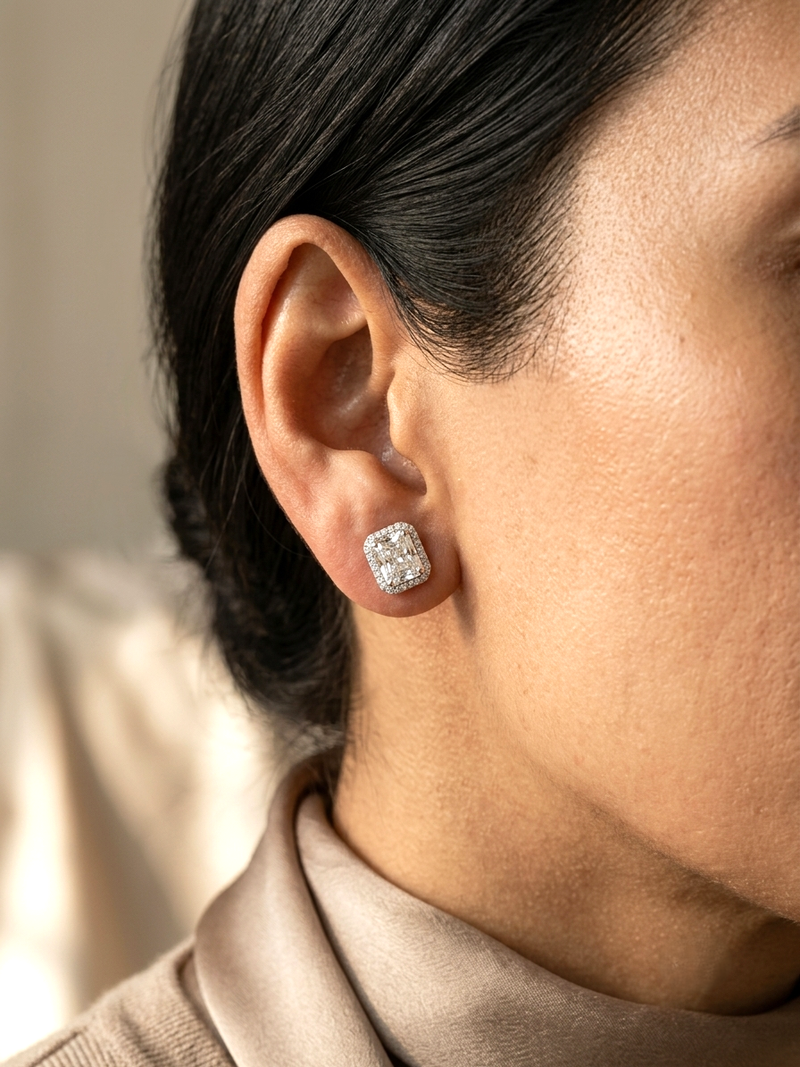 18K white gold diamond halo stud earrings featuring two GIA certified radiant cut diamonds totaling 1.40 carats surrounded by 0.27 carat natural diamond halos.
