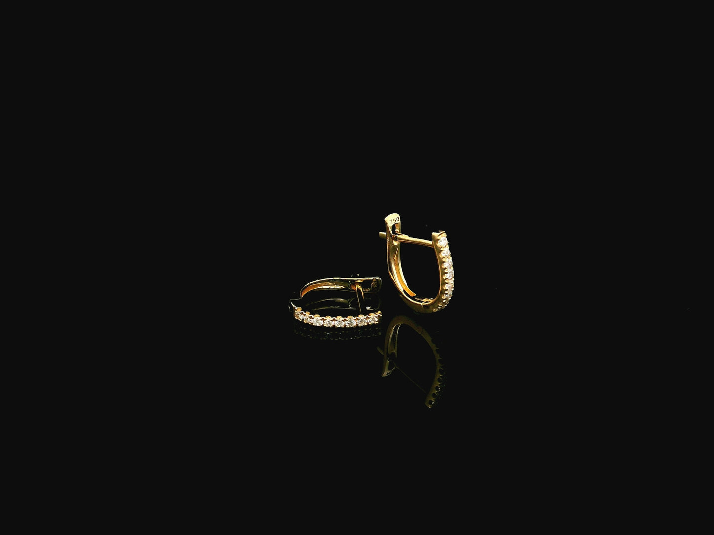 18K yellow gold diamond huggie hoop earrings featuring 0.09 carats of natural diamonds in a classic everyday hoop design.