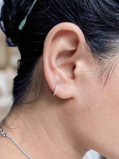 18K yellow gold diamond huggie hoop earrings featuring 0.09 carats of natural diamonds in a classic everyday hoop design.
