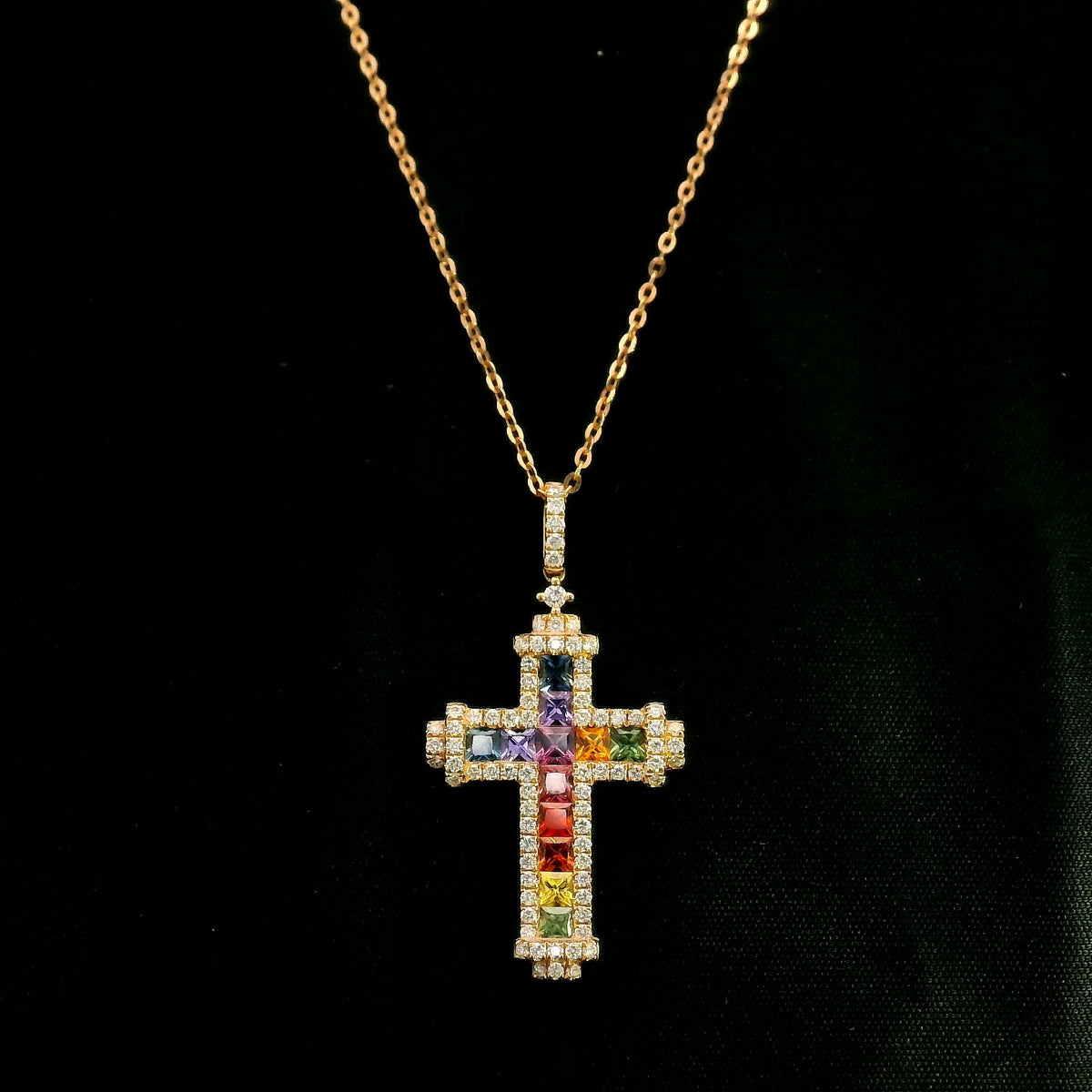 Multicolour sapphire and diamond cross necklace in 18K rose gold with colourful sapphires, diamond border and diamond-set bail.