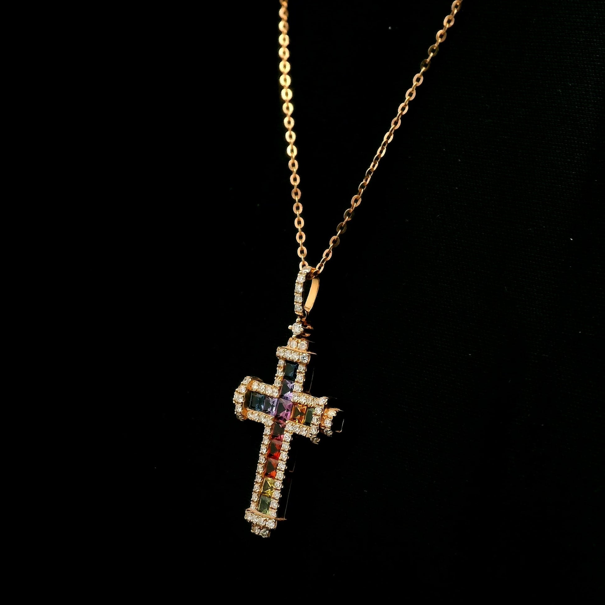 Multicolour sapphire and diamond cross necklace in 18K rose gold with colourful sapphires, diamond border and diamond-set bail.