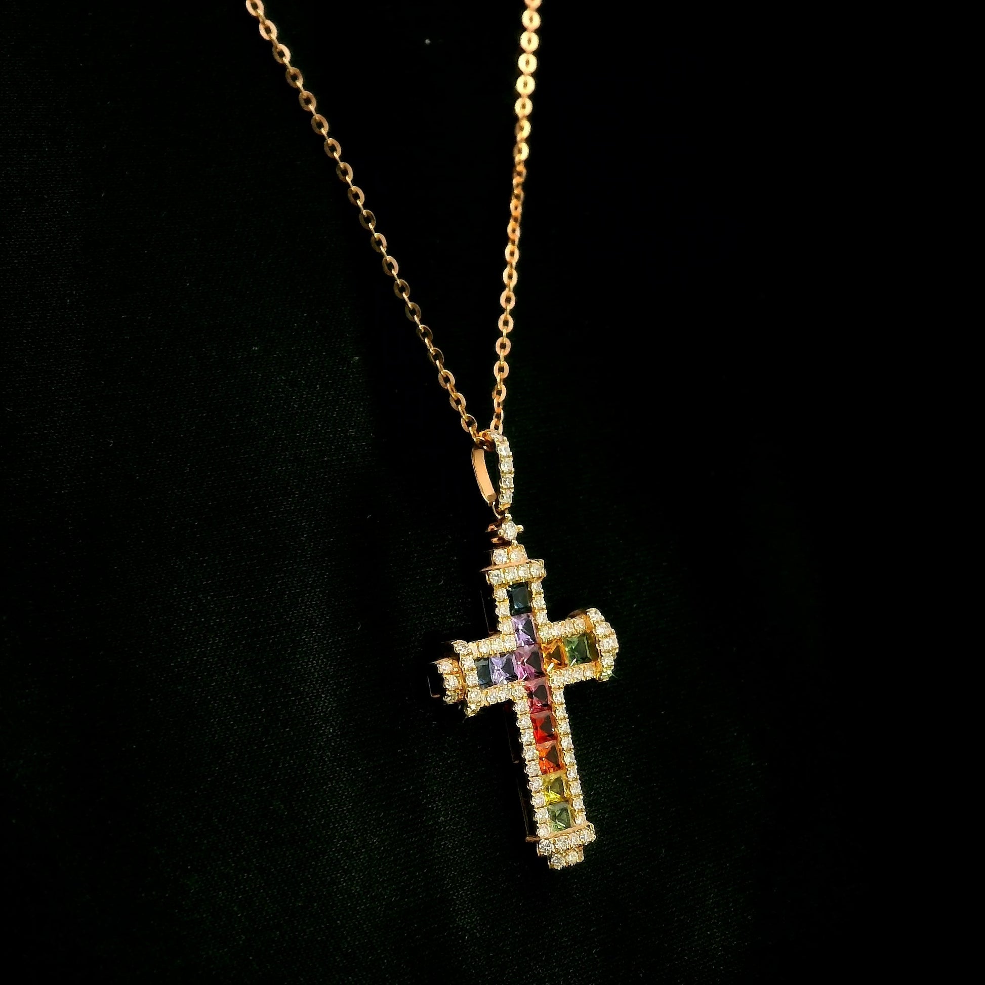 Multicolour sapphire and diamond cross necklace in 18K rose gold with colourful sapphires, diamond border and diamond-set bail.