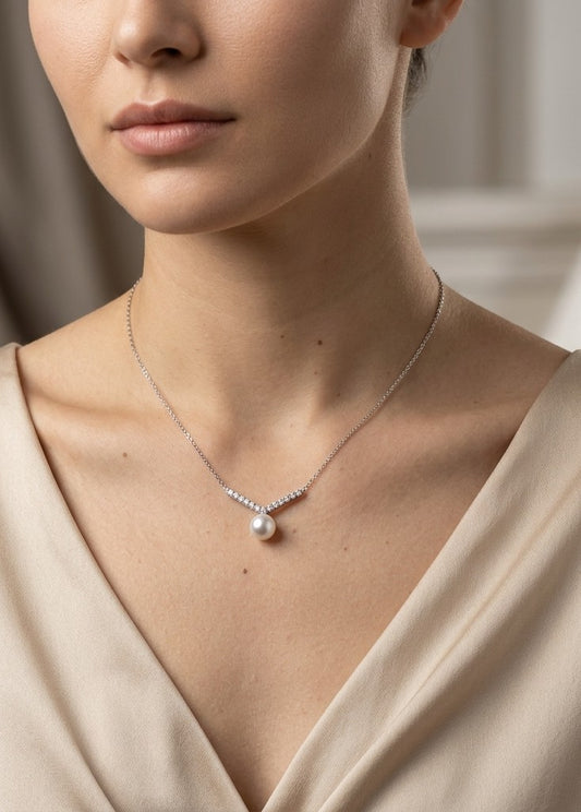 Freshwater pearl and diamond necklace in 18K white gold featuring a white pearl suspended beneath a gently curved row of round diamonds on a delicate white gold chain.