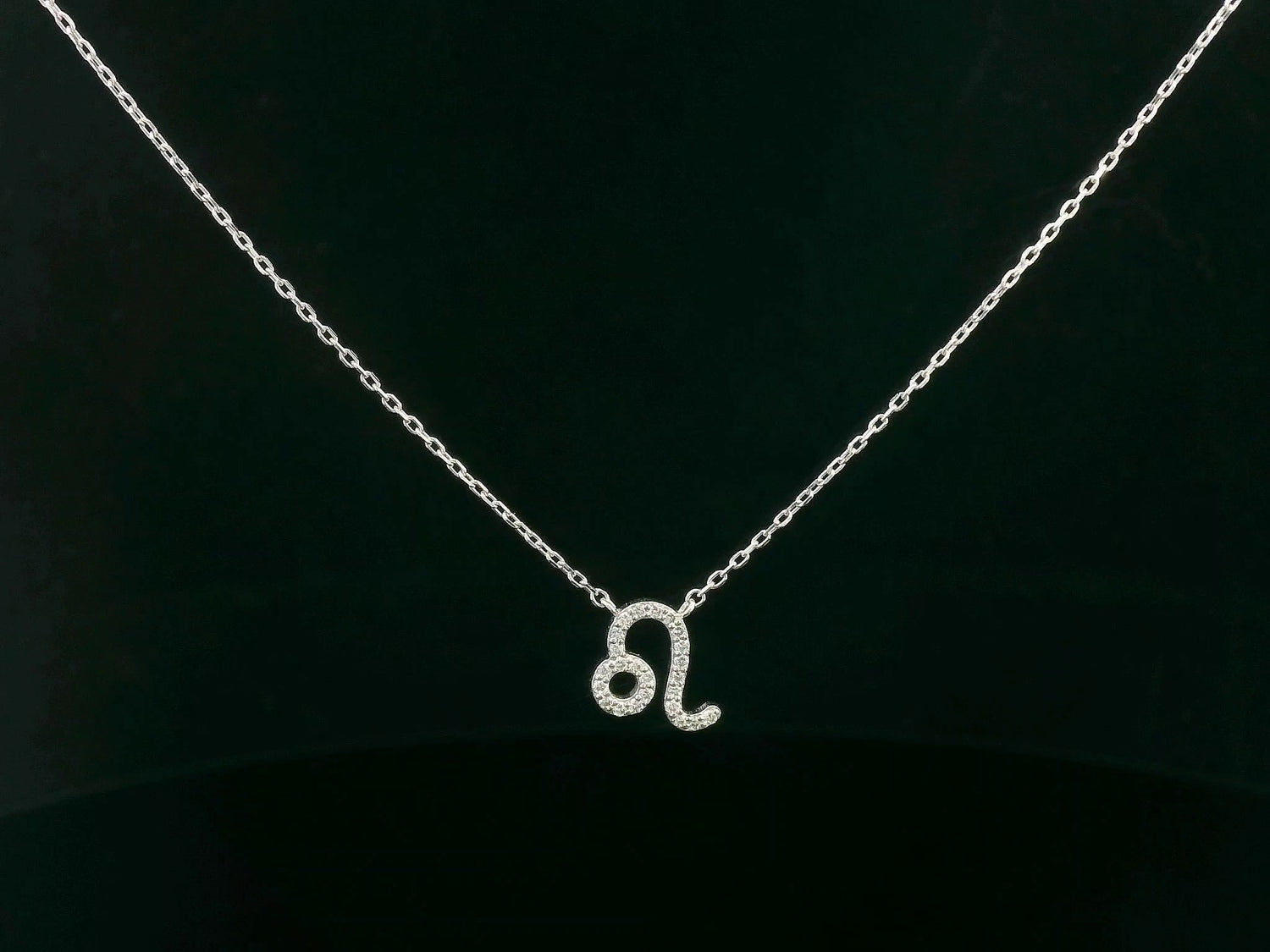 Leo zodiac sign necklace in 18K white gold with 0.08 carat diamond detailing.


