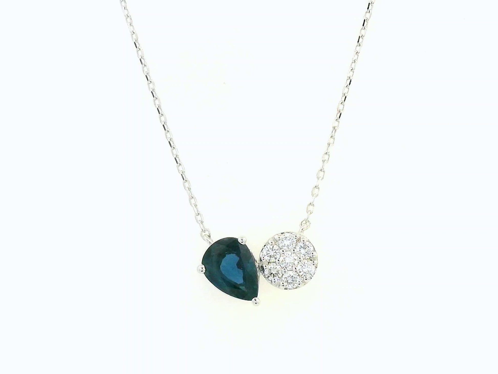 18K white gold pendant featuring a 0.97 carat pear-cut blue sapphire and 0.17 carat round diamond cluster on a fine gold chain.