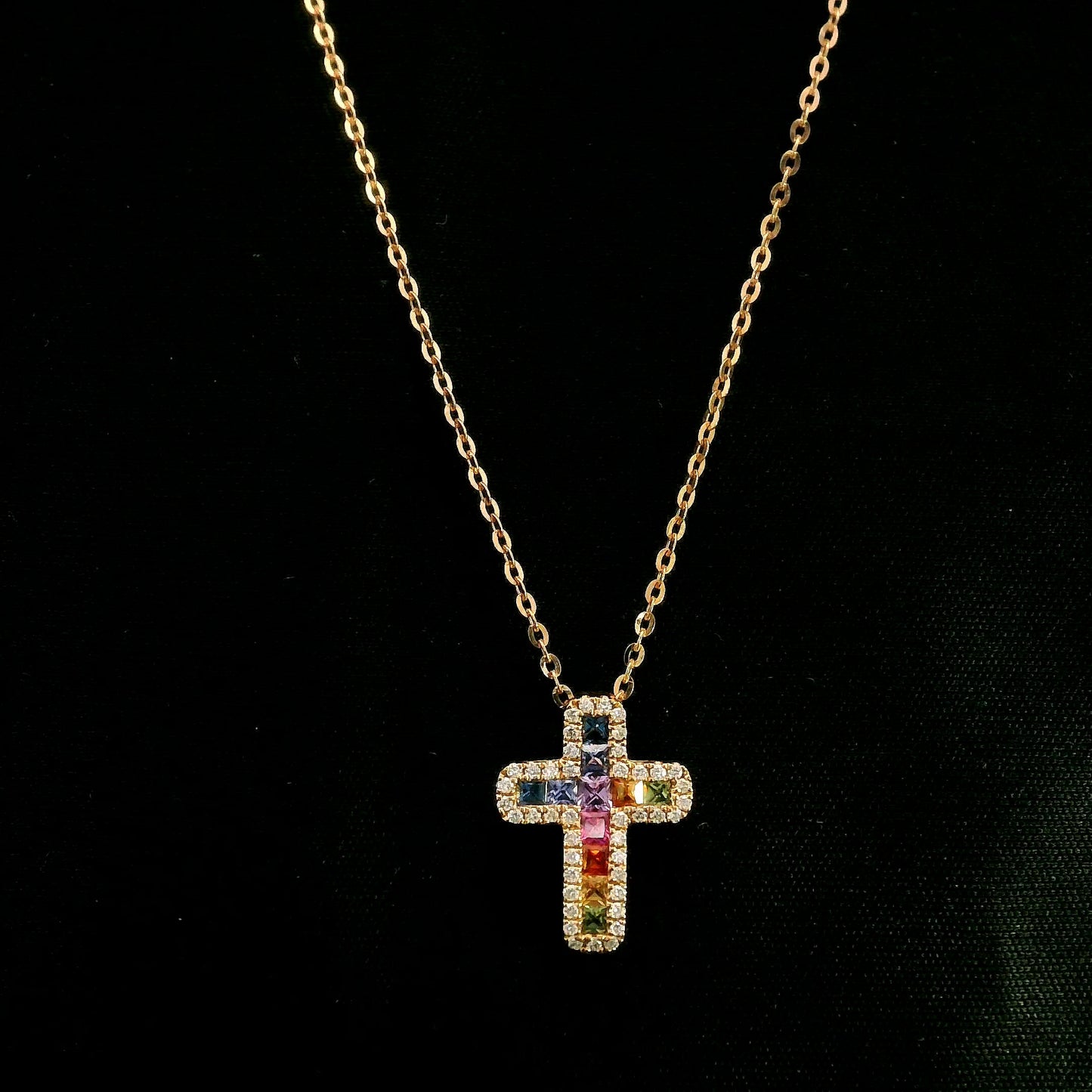 Multicolour sapphire and diamond cross necklace in 18K rose gold with colourful sapphires surrounded by round brilliant diamonds.