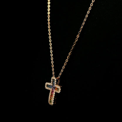 Multicolour sapphire and diamond cross necklace in 18K rose gold with colourful sapphires surrounded by round brilliant diamonds.