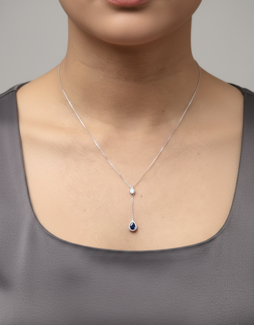 Blue sapphire and diamond drop necklace in 18K white gold pear-shaped sapphire with halo – Emirates Diamonds