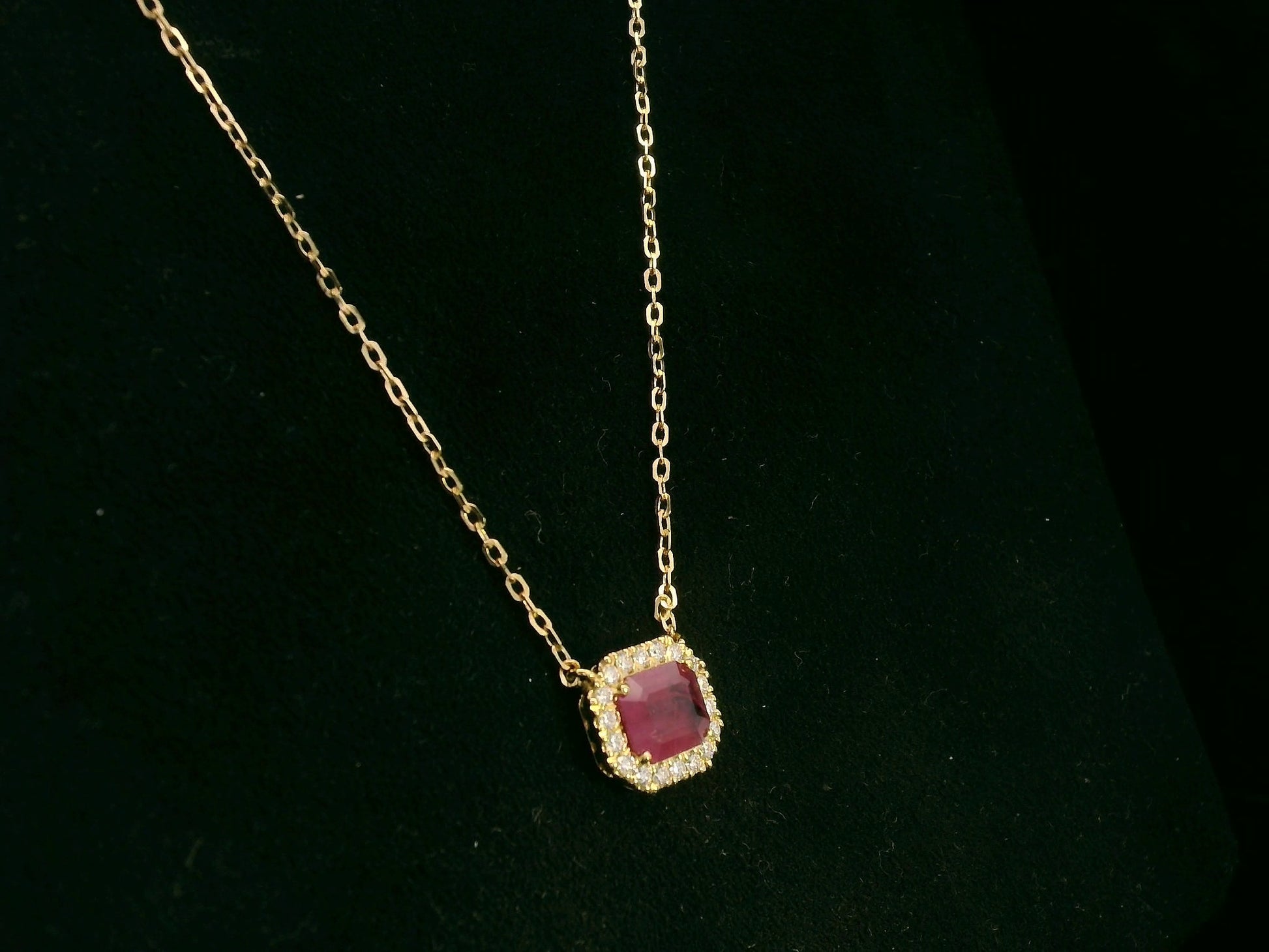 18K yellow gold ruby necklace with cushion-cut ruby and diamond halo by Emirates Diamonds
