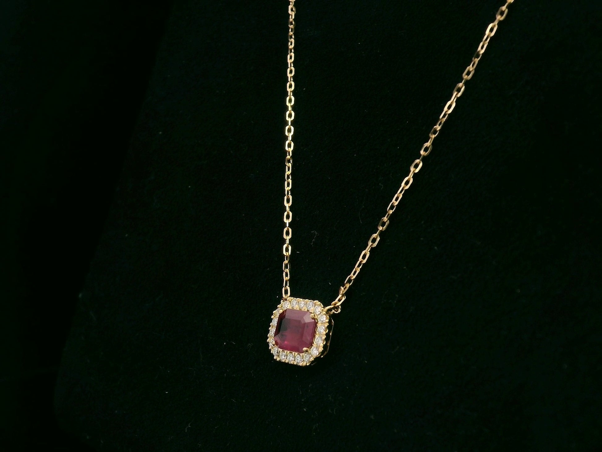 18K yellow gold ruby necklace with cushion-cut ruby and diamond halo by Emirates Diamonds