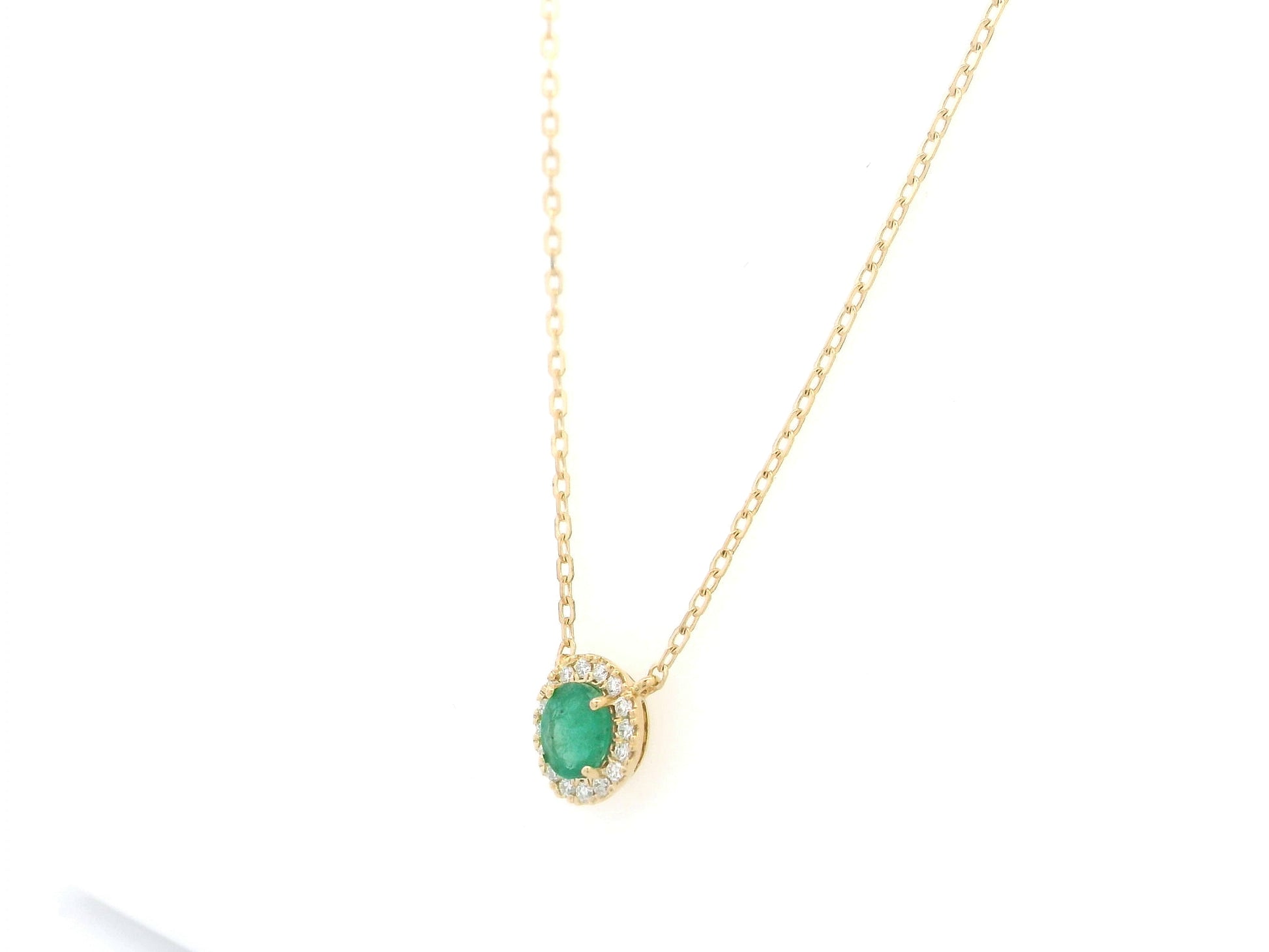 Emerald and diamond halo necklace in 18K yellow gold featuring 0.51 carat emerald and 0.10 carat diamonds by Emirates Diamonds.