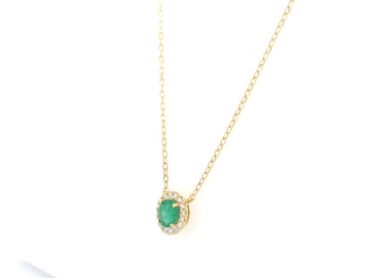Emerald and diamond halo necklace in 18K yellow gold featuring 0.51 carat emerald and 0.10 carat diamonds by Emirates Diamonds.