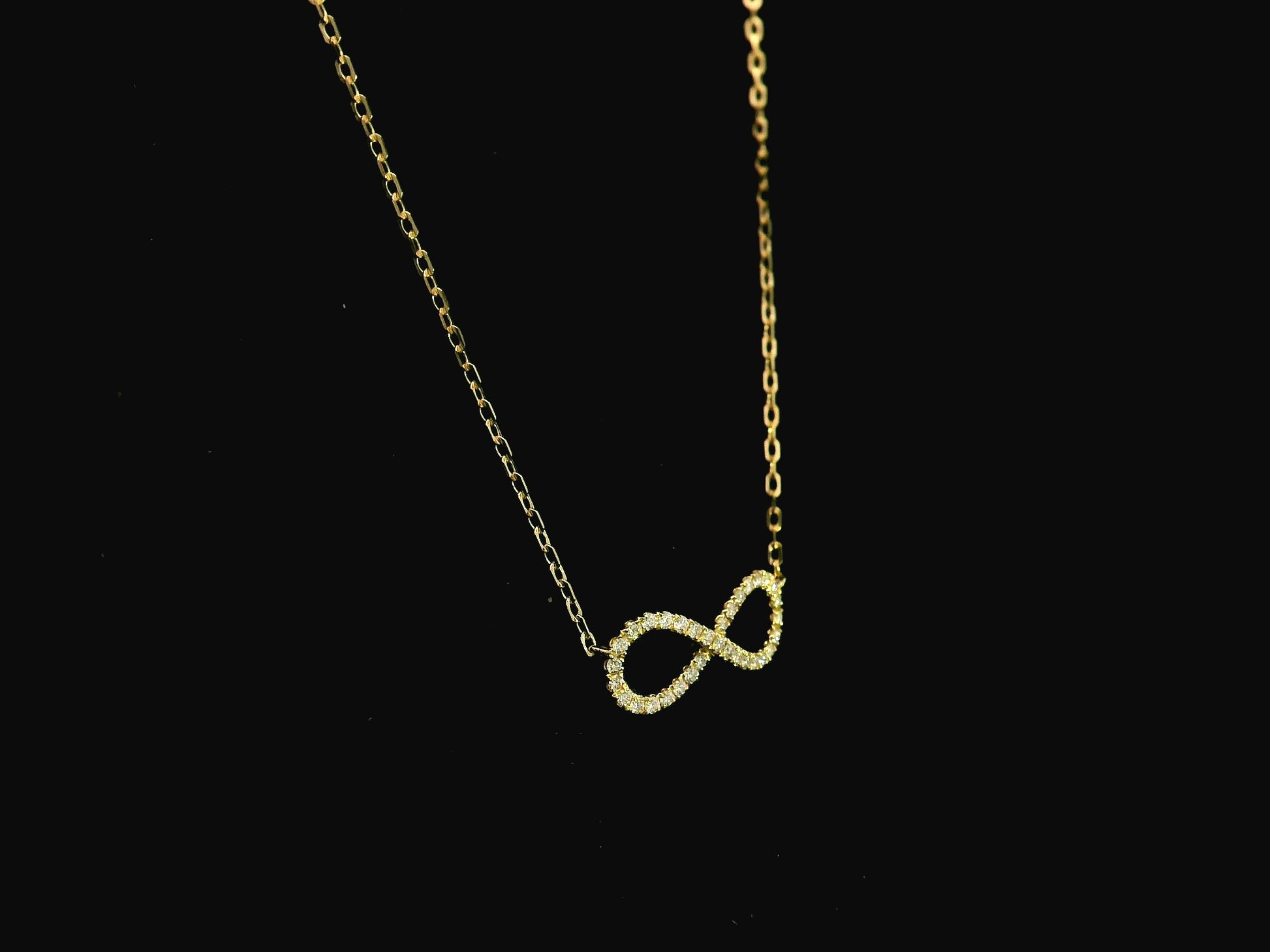 Diamond infinity necklace in 18K yellow gold featuring 0.19 carats of diamonds by Emirates Diamonds.