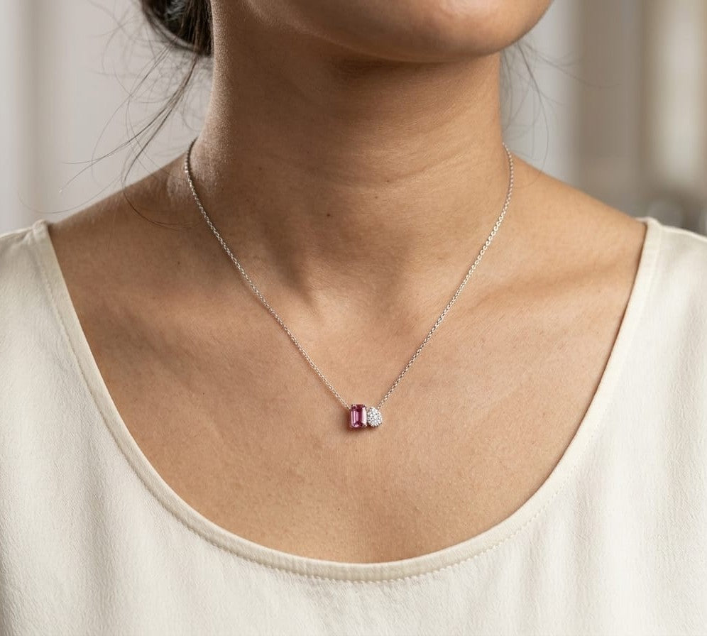 18K white gold pendant necklace featuring a 0.63 carat emerald cut pink sapphire paired with a 0.07 carat pear shaped diamond.