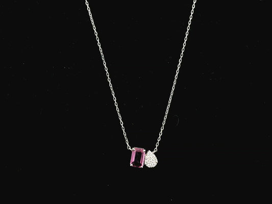 18K white gold pendant necklace featuring a 0.63 carat emerald cut pink sapphire paired with a 0.07 carat pear shaped diamond.