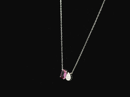 18K white gold pendant necklace featuring a 0.63 carat emerald cut pink sapphire paired with a 0.07 carat pear shaped diamond.