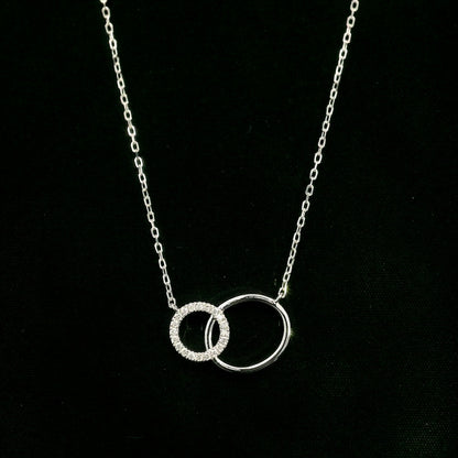 Interlocking circle diamond necklace in 18K white gold with one pavé diamond circle and one polished circle.