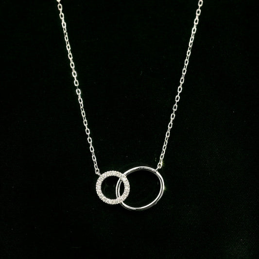 Interlocking circle diamond necklace in 18K white gold with one pavé diamond circle and one polished circle.