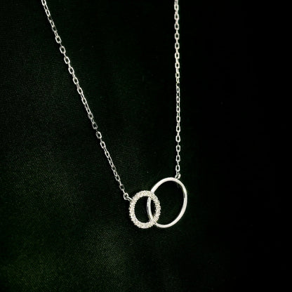 Interlocking circle diamond necklace in 18K white gold with one pavé diamond circle and one polished circle.