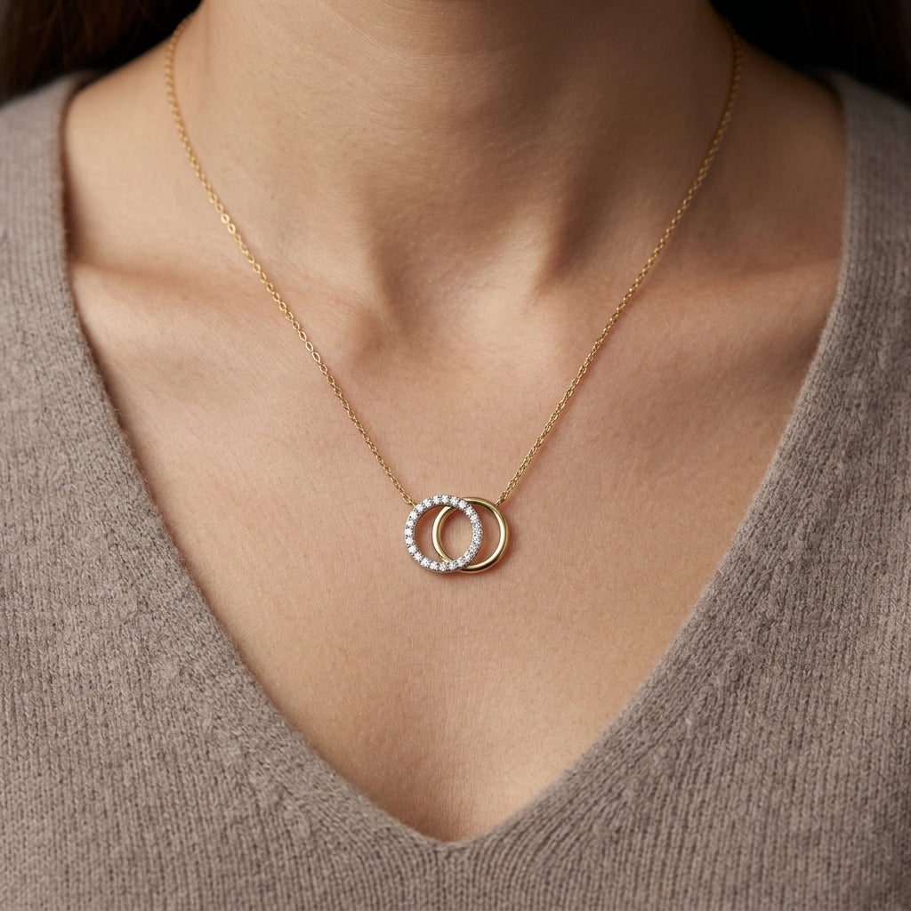 Interlocking diamond circle necklace in 18K yellow gold with one diamond-set circle and one polished gold circle.