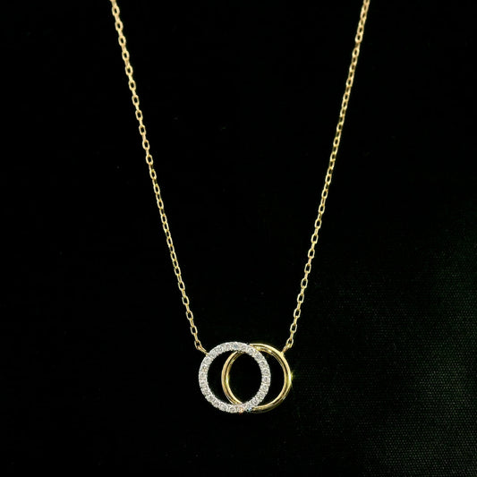 Interlocking diamond circle necklace in 18K yellow gold with one diamond-set circle and one polished gold circle.