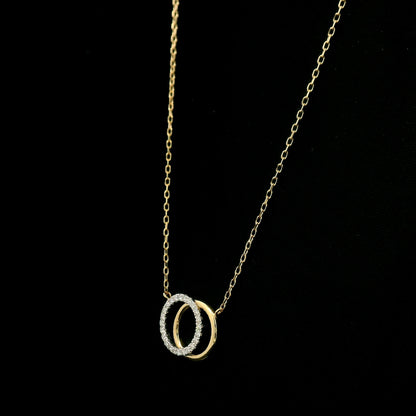 Interlocking diamond circle necklace in 18K yellow gold with one diamond-set circle and one polished gold circle.