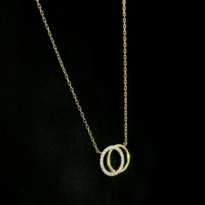 Interlocking diamond circle necklace in 18K yellow gold with one diamond-set circle and one polished gold circle.