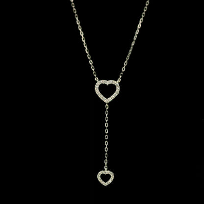 Diamond double heart Y necklace in 18K white gold featuring a larger open diamond heart at the neckline and a smaller diamond heart suspended from a delicate vertical drop chain, with 0.23 carat total diamond weight.