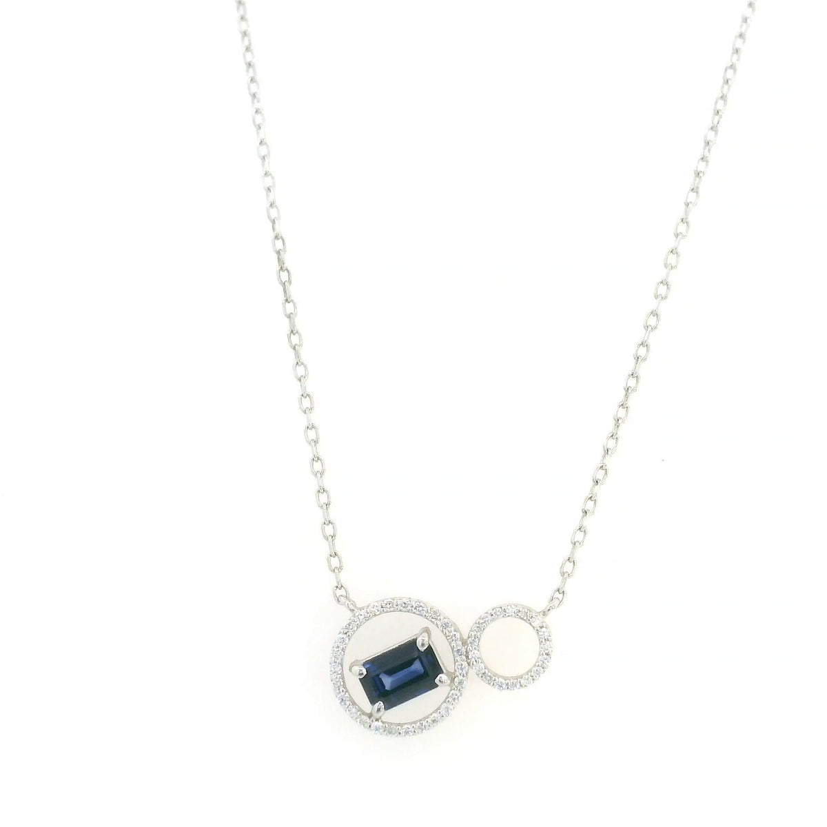 Blue emerald-cut sapphire and diamond necklace in 18K white gold, featuring an asymmetrical double-circle design with round diamond accents.