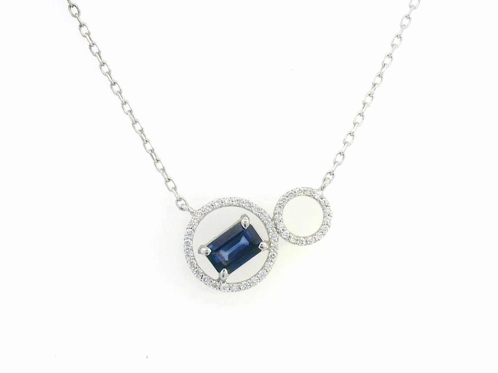 18K white gold necklace featuring a 0.65 CT emerald-cut sapphire with a 0.15 CT diamond halo, designed with a unique double-circle pendant for a sophisticated, modern look.