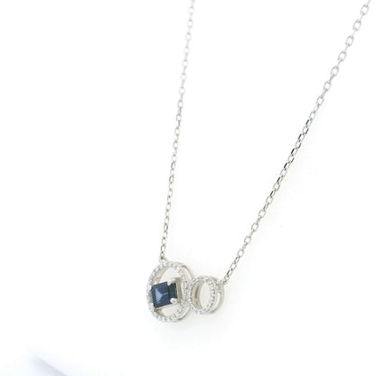 Blue emerald-cut sapphire and diamond necklace in 18K white gold, featuring an asymmetrical double-circle design with round diamond accents.