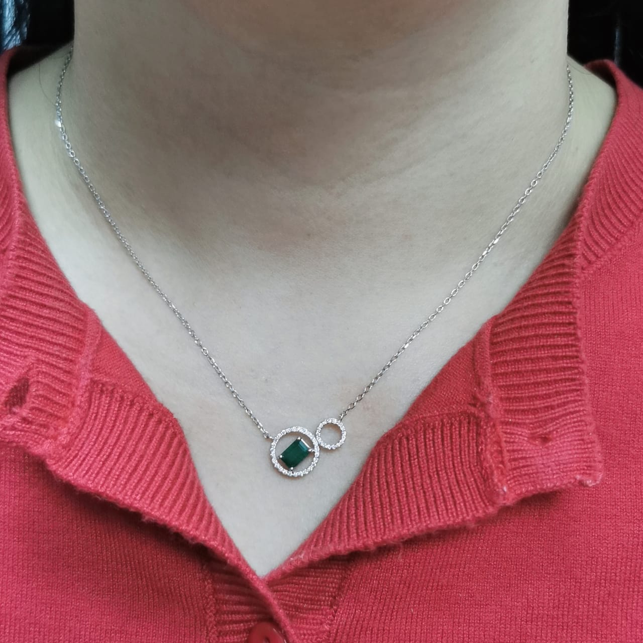 18K white gold necklace featuring a 0.63ct emerald-cut emerald and 0.15ct diamond double-circle pendant, designed for modern elegance and layering versatility