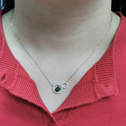 18K white gold necklace featuring a 0.63ct emerald-cut emerald and 0.15ct diamond double-circle pendant, designed for modern elegance and layering versatility