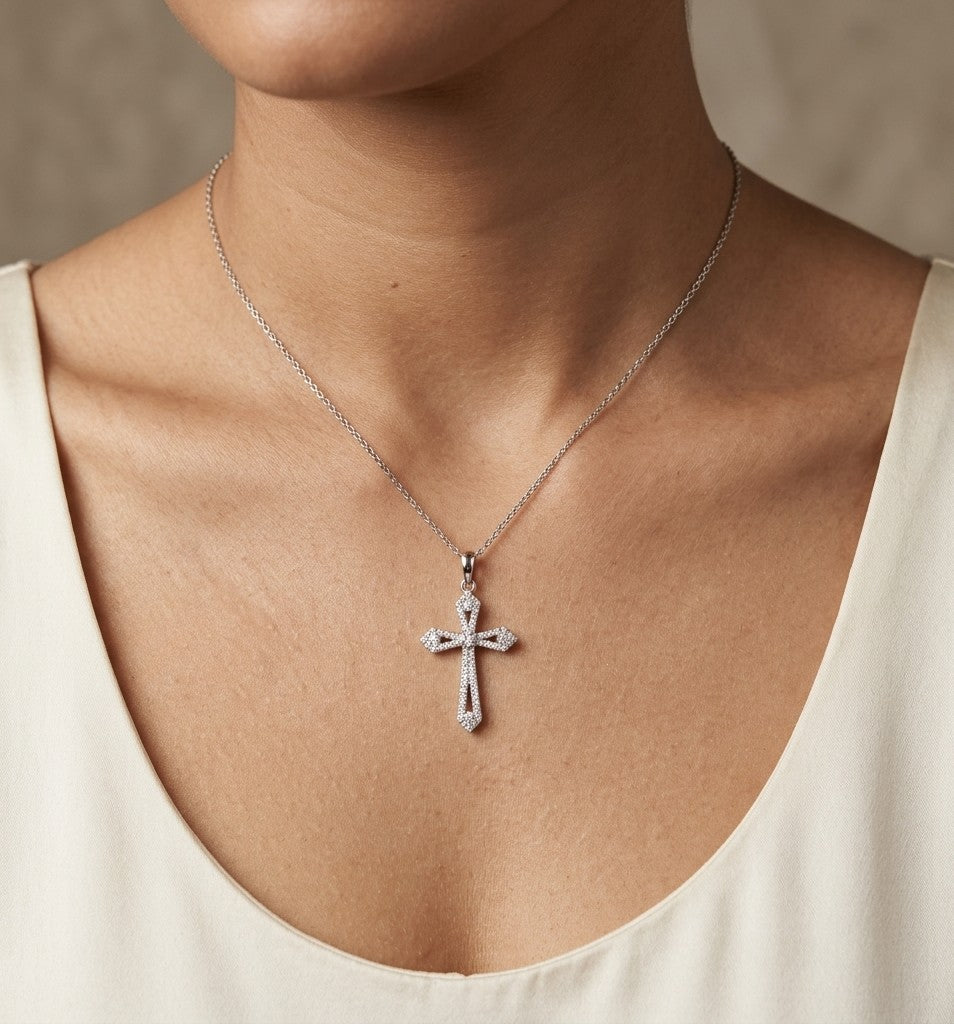 Diamond cross pendant in 18K white gold with round diamonds, an openwork design and distinctive pointed ends.