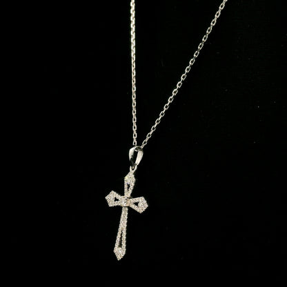 Diamond cross pendant in 18K white gold with round diamonds, an openwork design and distinctive pointed ends.