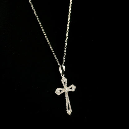 Diamond cross pendant in 18K white gold with round diamonds, an openwork design and distinctive pointed ends.