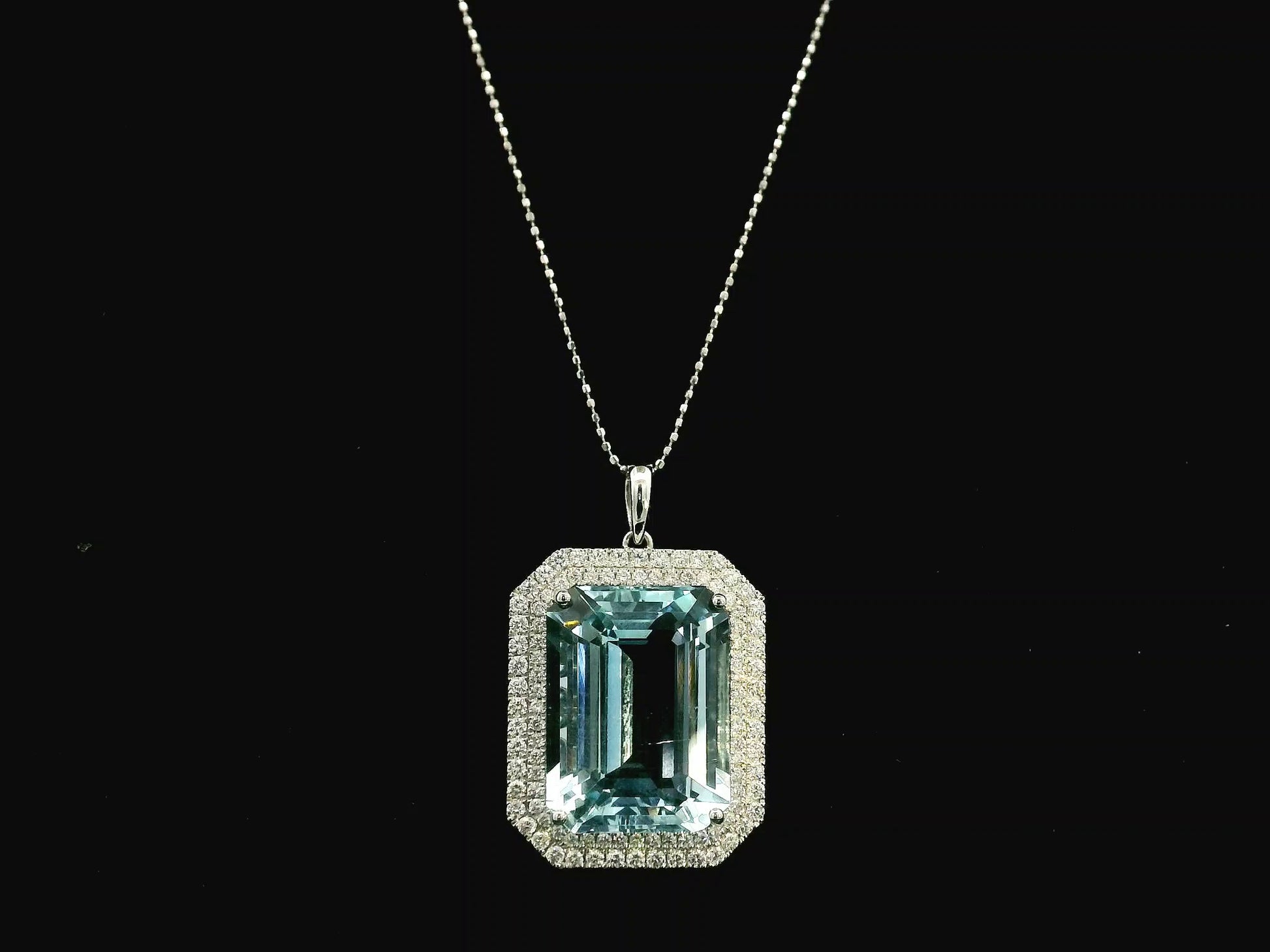 Emerald-cut aquamarine and diamond halo pendant in 18K white gold with large natural aquamarine center stone