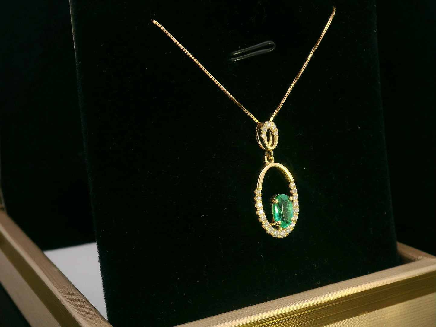 18K gold emerald and diamond oval pendant featuring a 0.42ct green emerald and 0.15ct diamonds, designed for layering—pair with various chain styles for a trendy, personalized look.