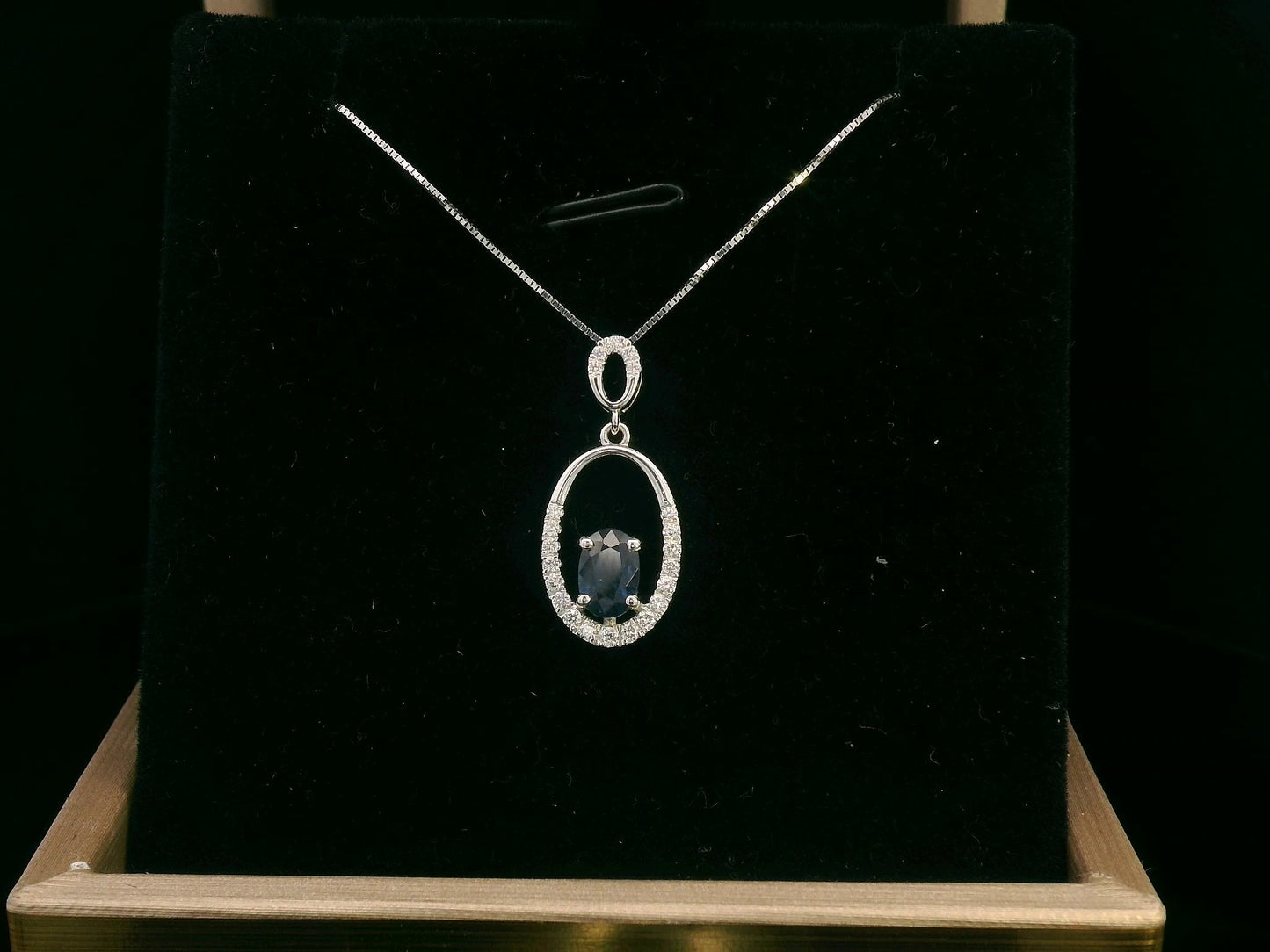 18K white gold oval pendant featuring a 0.70 carat sapphire with 0.15 carats of diamonds