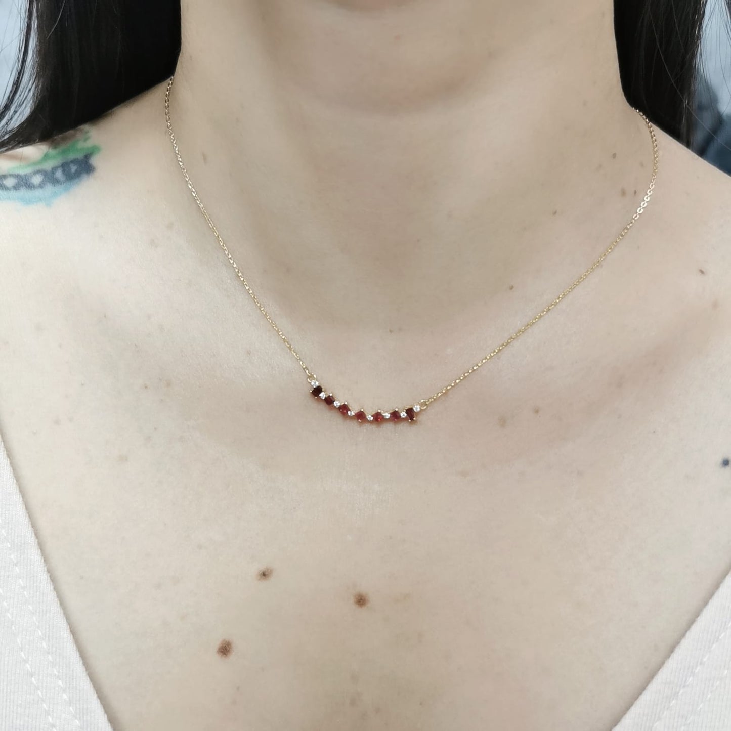 Elegant 18K gold necklace with square-cut rubies (0.67ct) and round diamonds (0.08ct), set on a fine gold chain – perfect July birthstone jewelry.