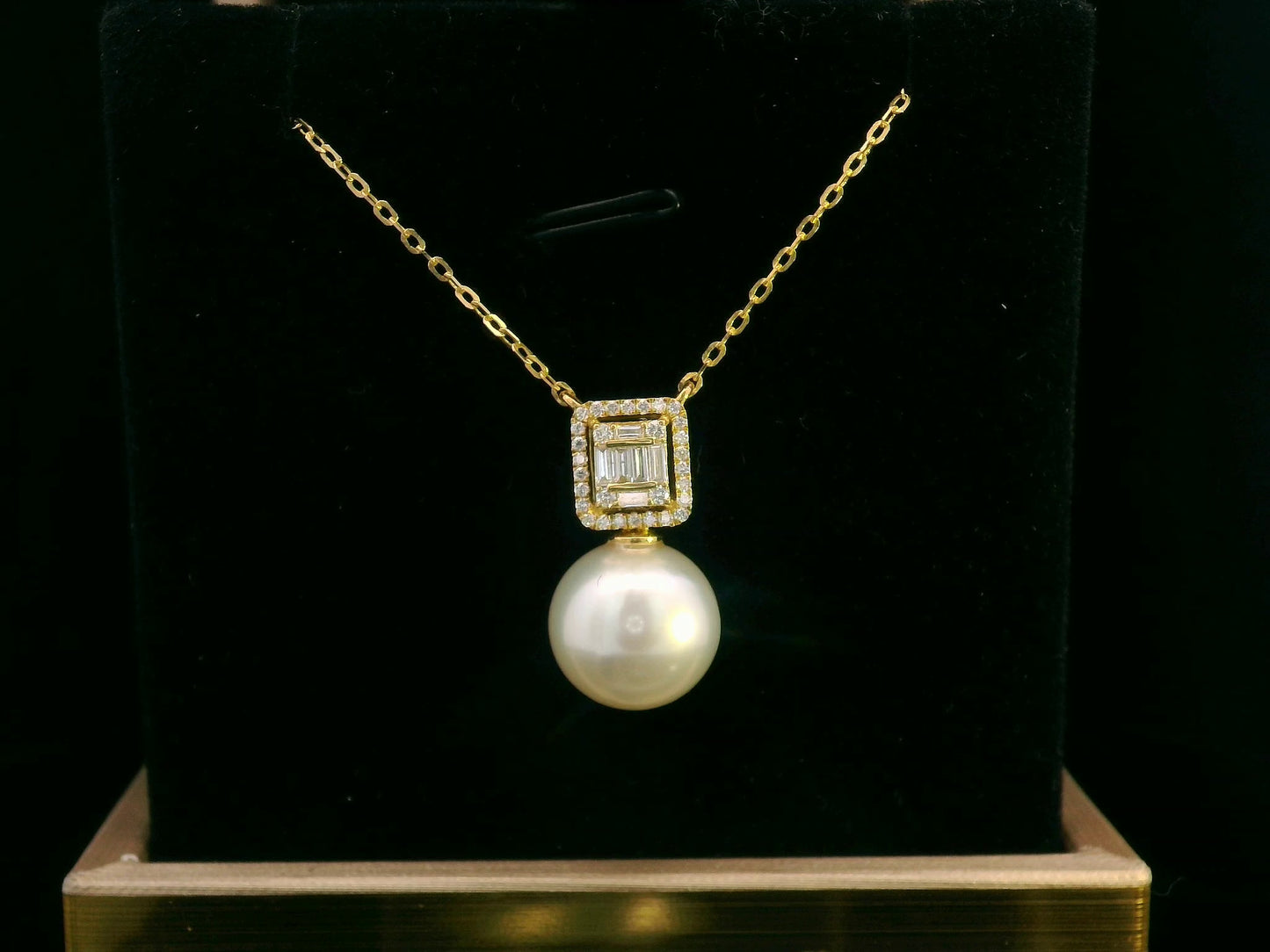 18K gold pendant featuring a South Sea pearl with a 0.26ct diamond halo of baguette and round diamonds.