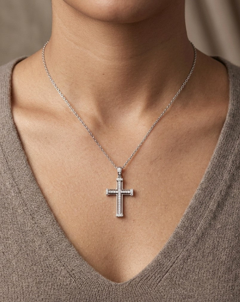 Diamond cross pendant in 18K white gold featuring an openwork design with round diamonds and diamond-accented ends.