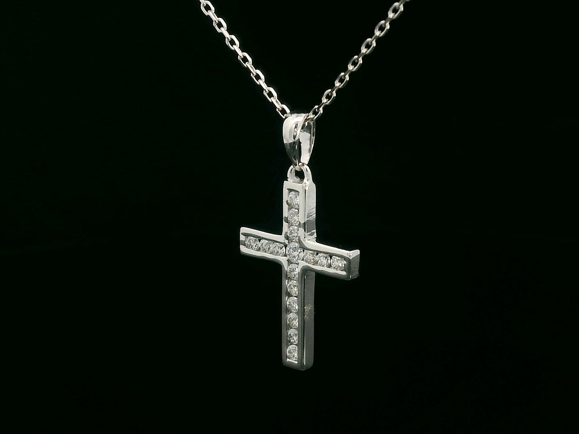 18K gold cross pendant with 0.20 carat round diamonds, religious charm on black background

