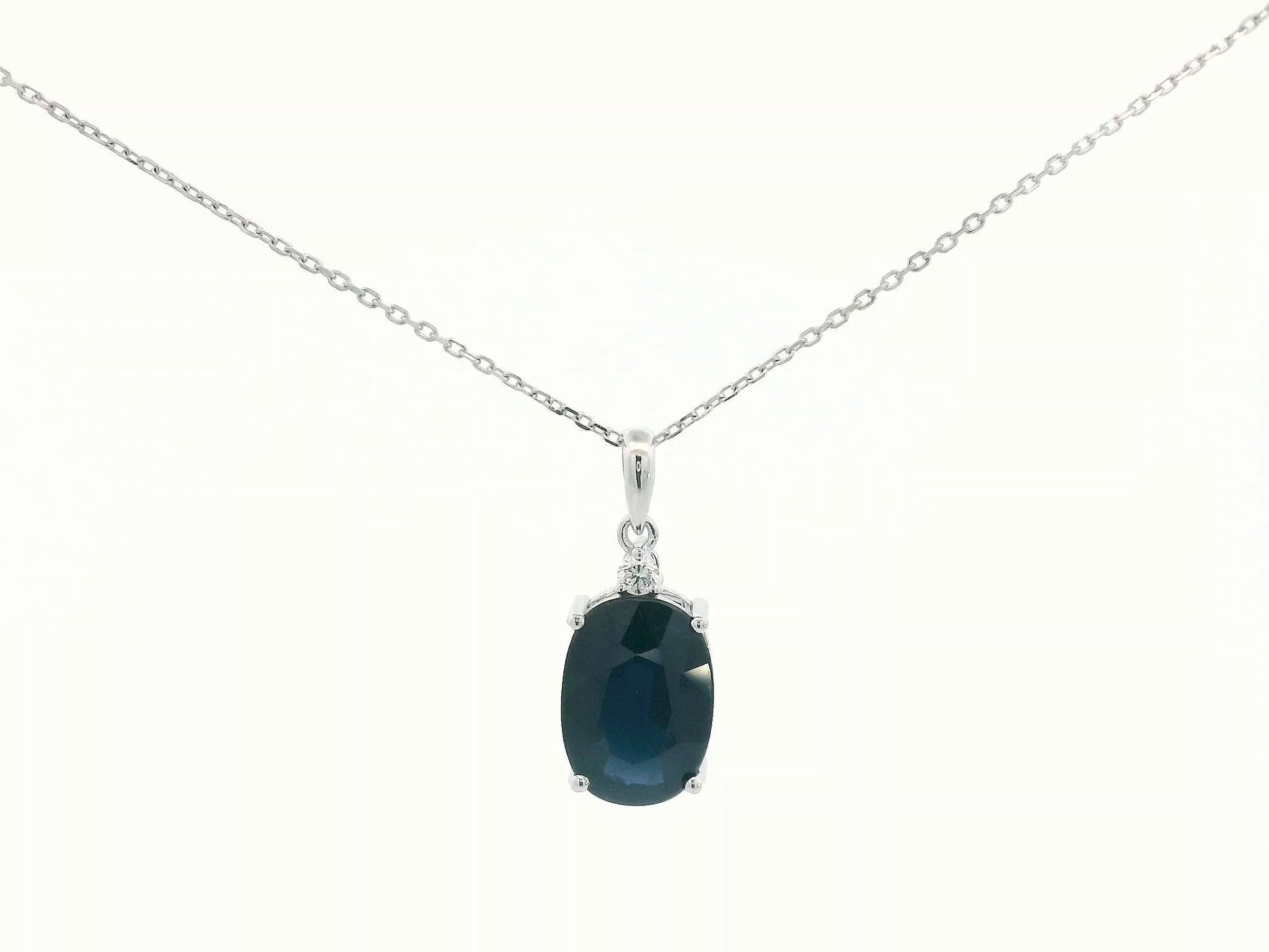 Oval-cut blue sapphire pendant with round diamond in white gold