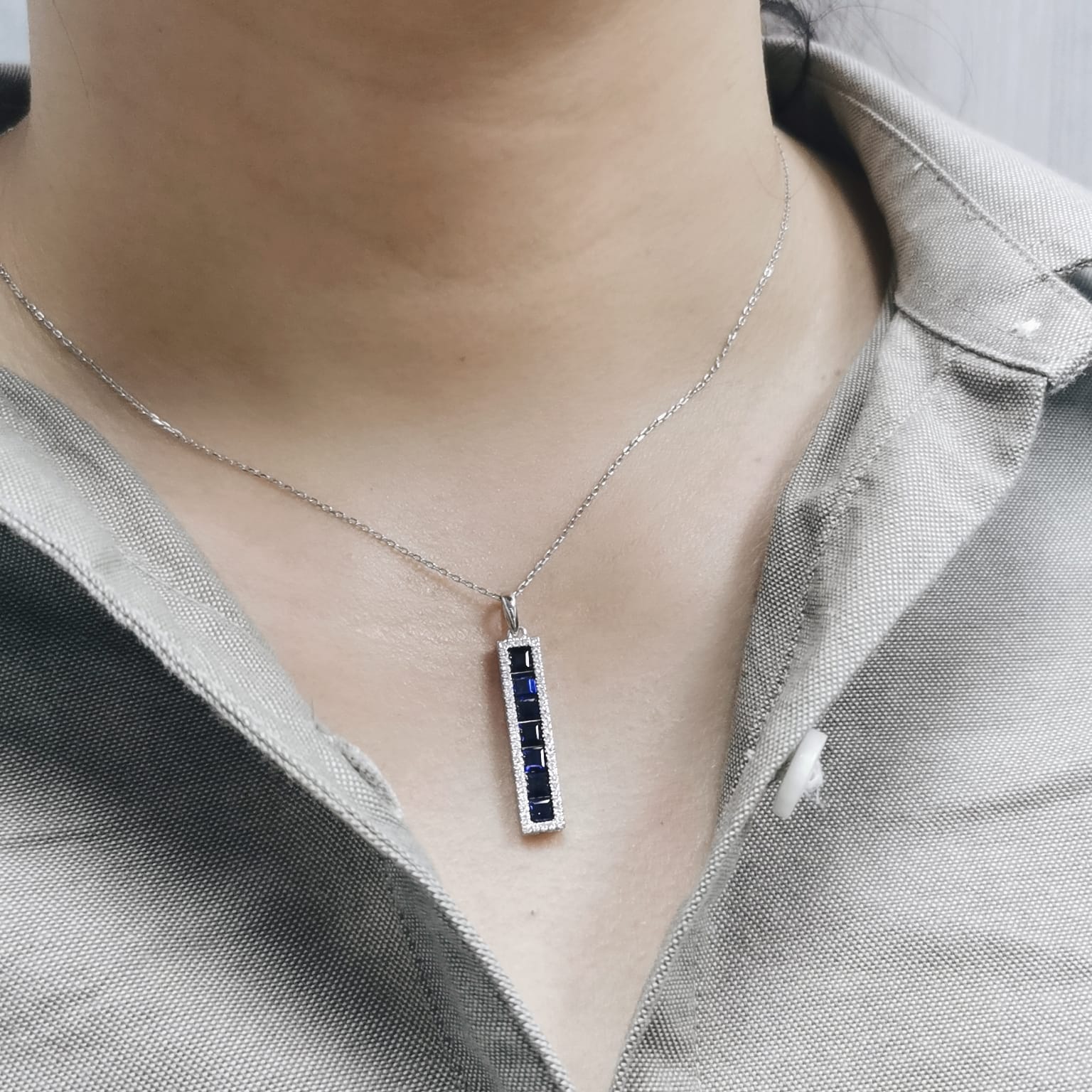 Fine jewelry pendant with blue sapphires framed by diamonds