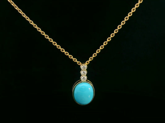 18K yellow gold pendant with 2.46ct oval turquoise and 0.14ct diamond accents.