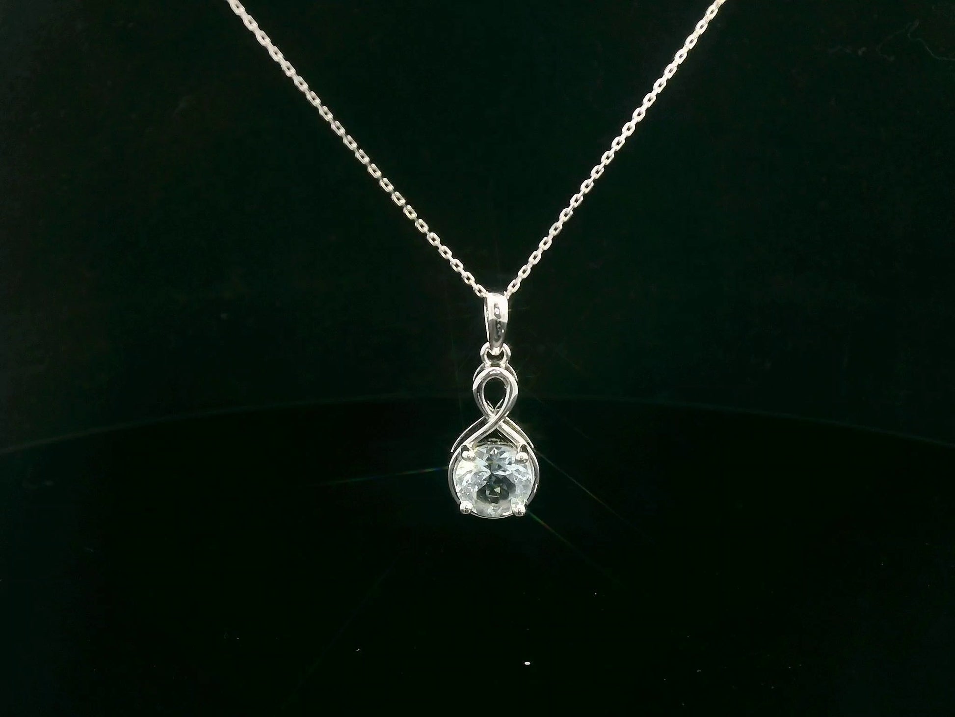18k white gold pendant with 1.10-carat round-cut aquamarine in infinity-style bail design